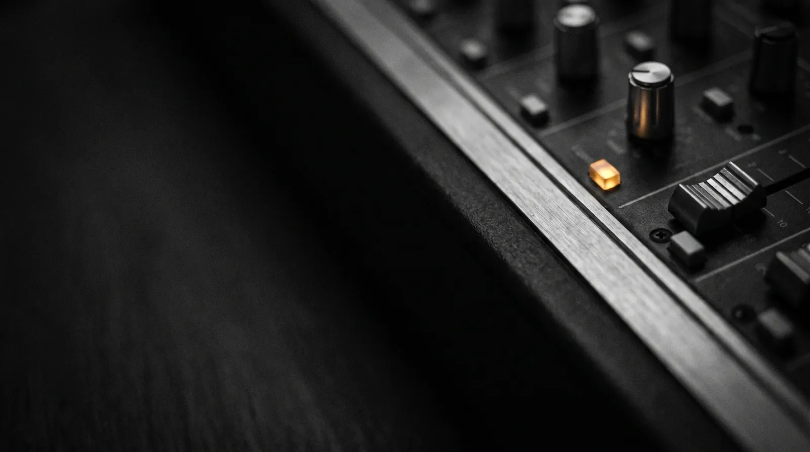 Illustrative close-up of console faders in a dark edit bay